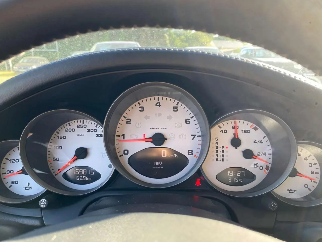Vue rapprochée du tableau de bord blanc de la Porsche 911 997 Carrera 4S gris météore, avec compte-tours central et affichages numériques.