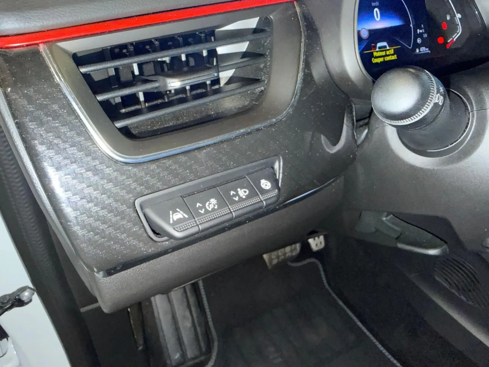 Vue intérieure côté conducteur du tableau de bord noir avec commandes d’aides à la conduite et ventilation sur Renault Arkana blanc nacré.