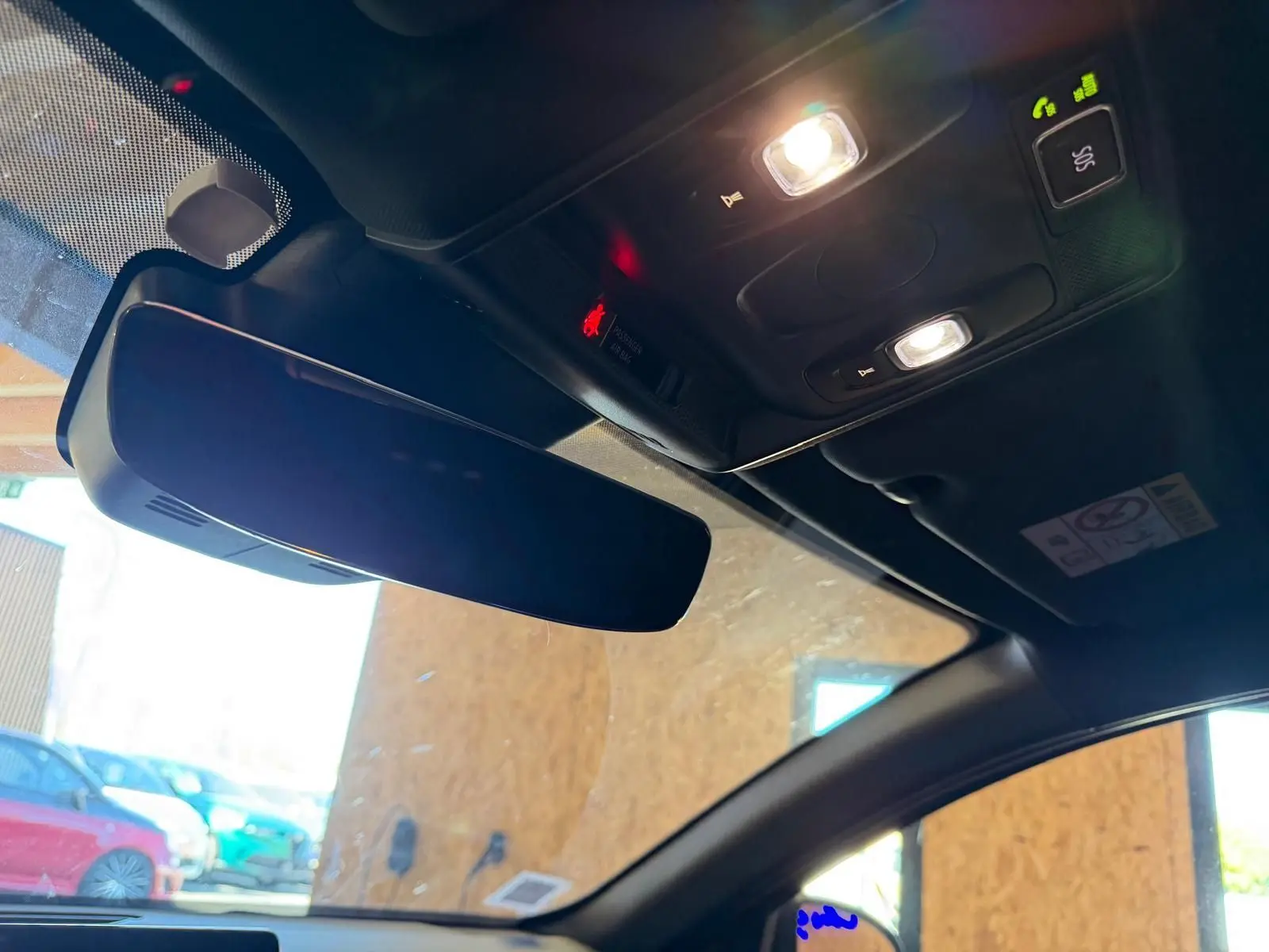 Vue intérieure du rétroviseur central et plafonnier avec éclairage allumé dans un Renault Arkana blanc nacré.