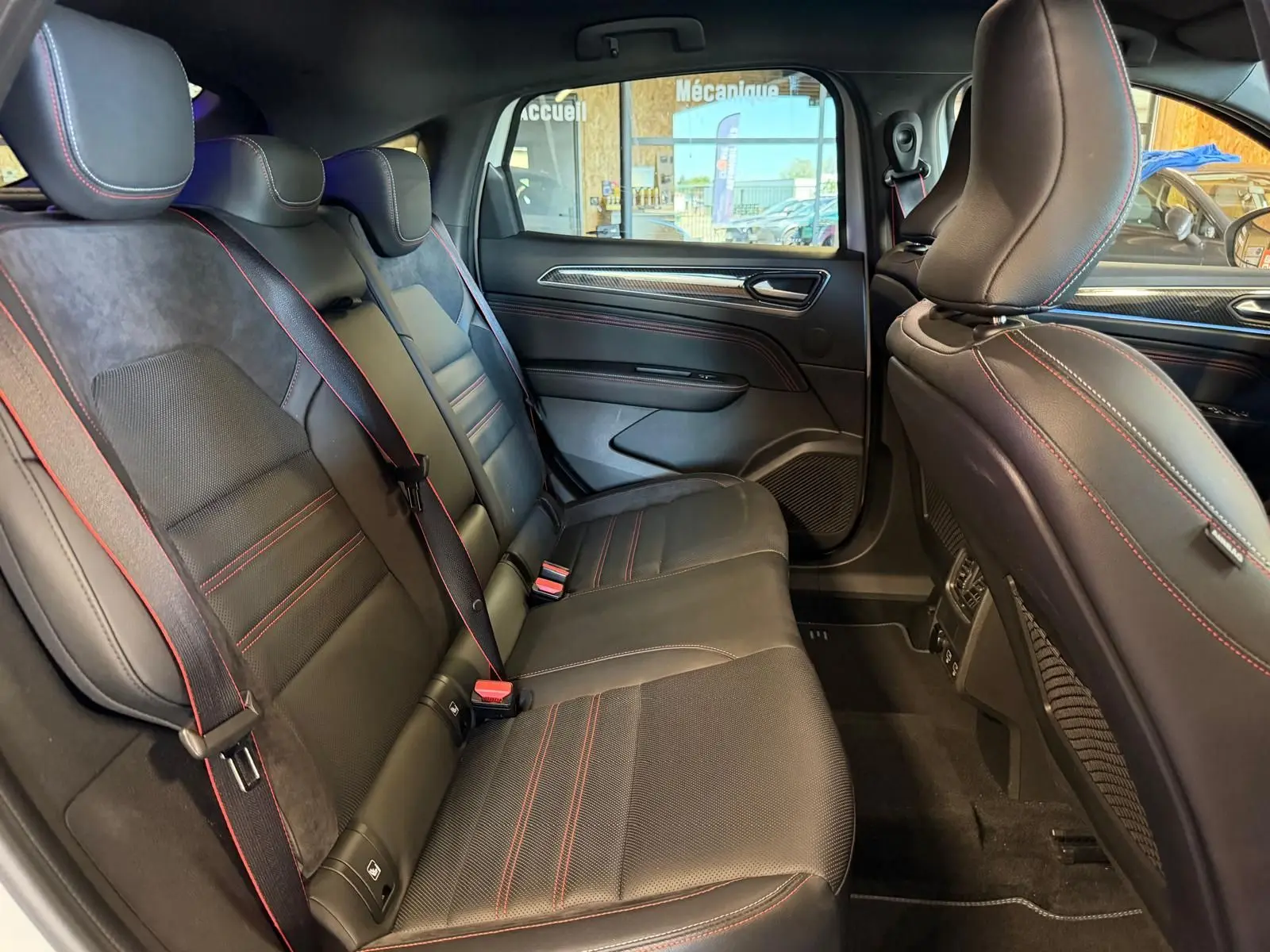 Vue latérale intérieure montrant la banquette arrière noire avec surpiqûres rouges du Renault Arkana 1.6 E-Tech hybrid RS LINE.