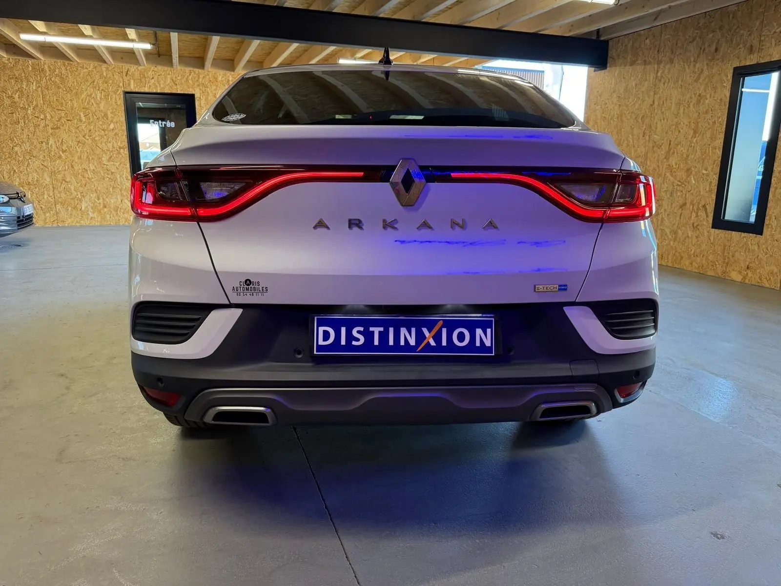 Vue arrière d'une Renault Arkana blanc nacré avec feux LED en forme de vague et double sortie d'échappement chromée.