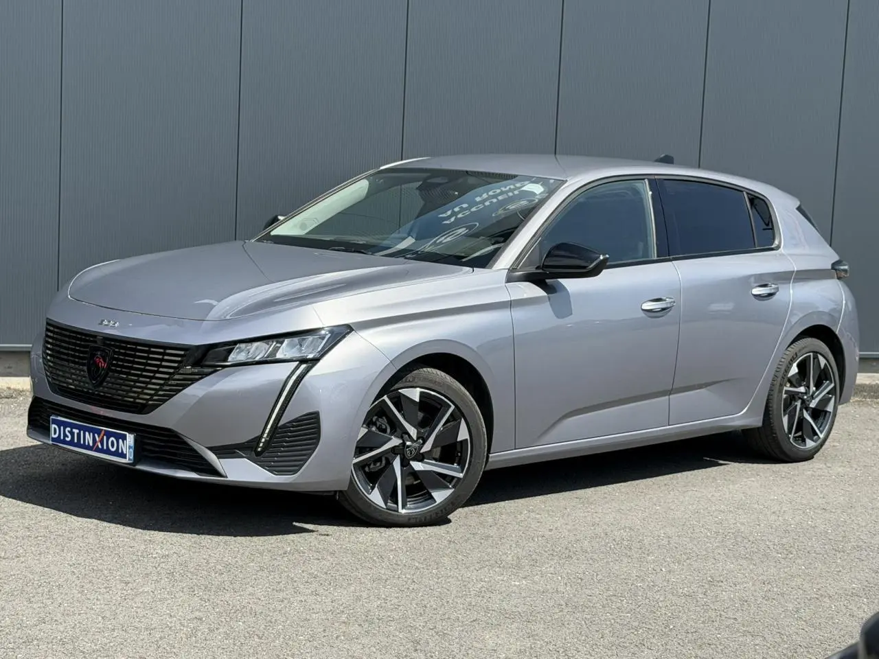 Peugeot 308 Hybrid gris Artense vue 3/4 avant droit, jantes alliage 17'' Halong diamantées et vitres surteintées.