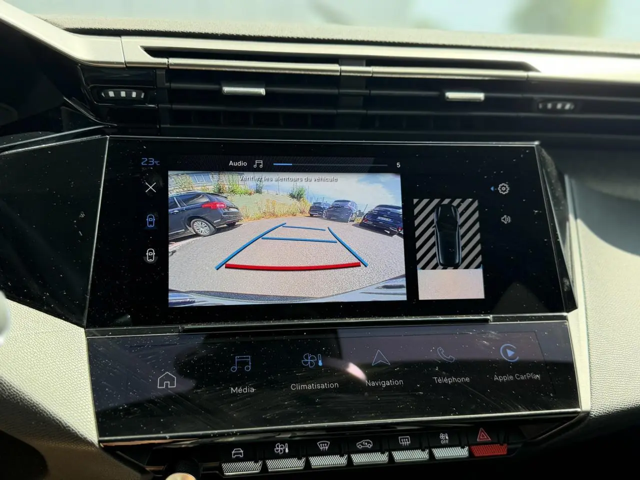 Écran tactile central de la Peugeot 308 Hybrid 2025 montrant la caméra de recul et l’aide au stationnement.