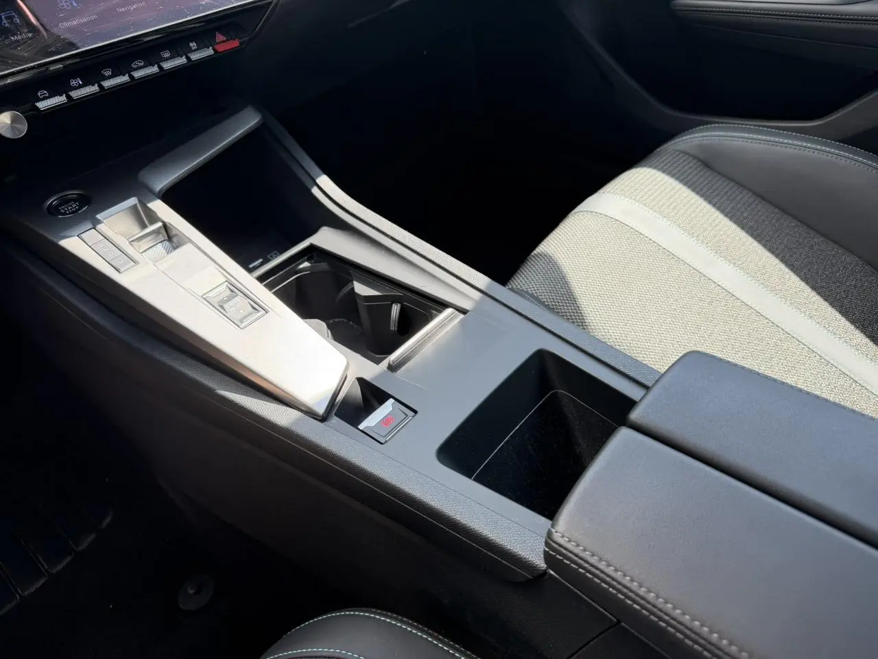 Détail de la console centrale et siège avant droit gris clair de la Peugeot 308 Hybrid 2025 finition Allure.