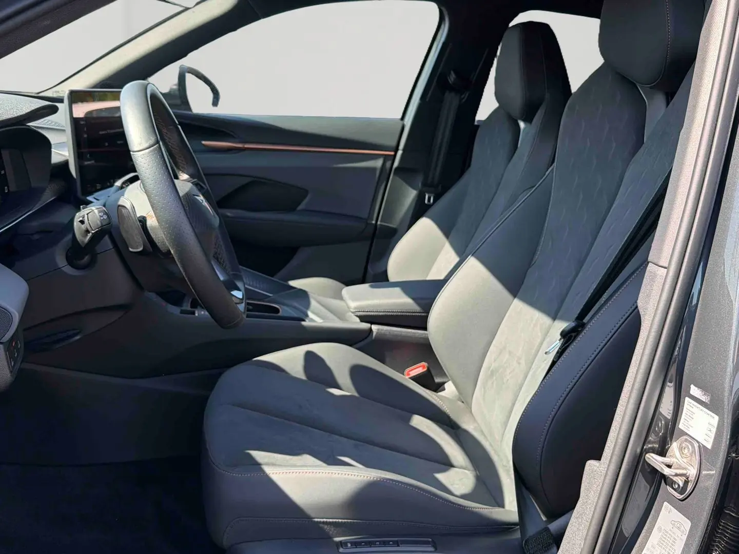 Vue intérieure côté conducteur de la CUPRA TERRAMAR 1.5 eHybrid grise, sièges avant en cuir et alcantara avec réglages électriques.