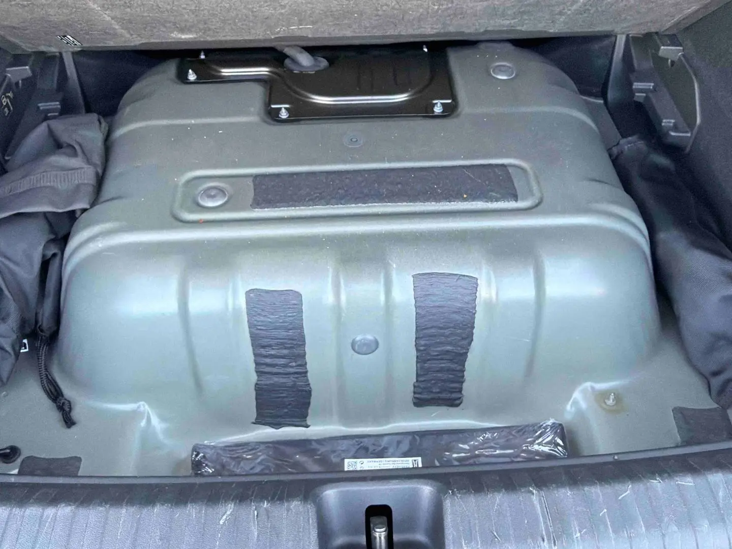 Vue du coffre ouvert d'une CUPRA TERRAMAR 2025 gris, montrant la partie inférieure du compartiment de rangement.