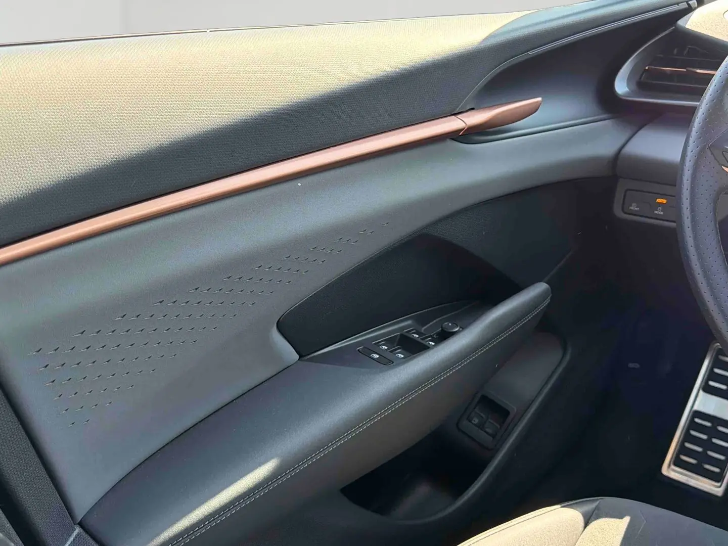 Vue intérieure côté conducteur du CUPRA TERRAMAR 2025, montrant la porte avec commandes électriques et garniture grise élégante.