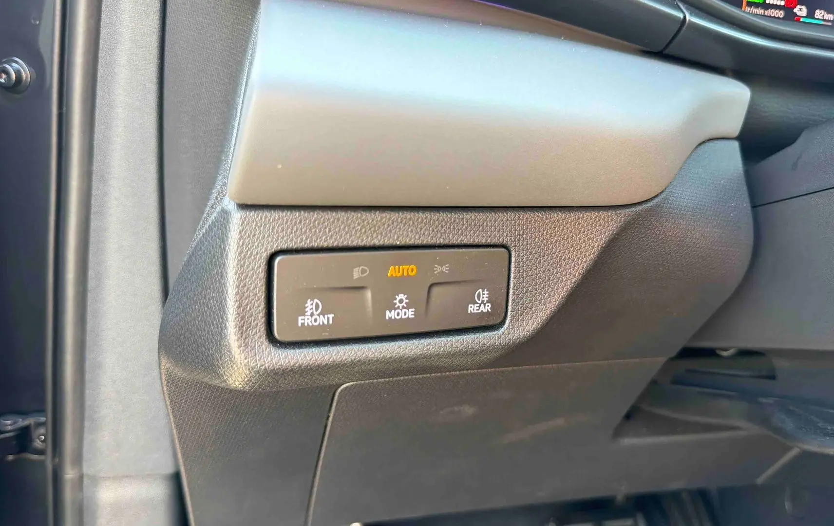 Gros plan sur les commandes d’éclairage au tableau de bord d’une CUPRA TERRAMAR 1.5 eHybrid grise, intérieur noir.