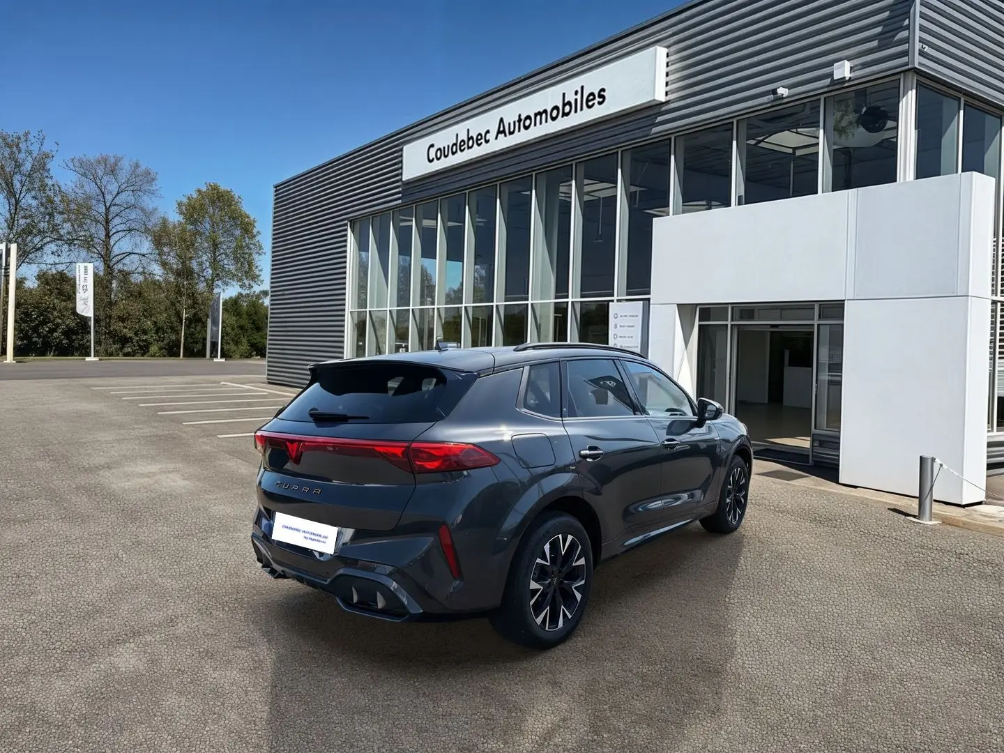 Vue 3/4 arrière droite d'une CUPRA Terramar grise 2025, avec jantes anthracites et feux arrière LED distinctifs.