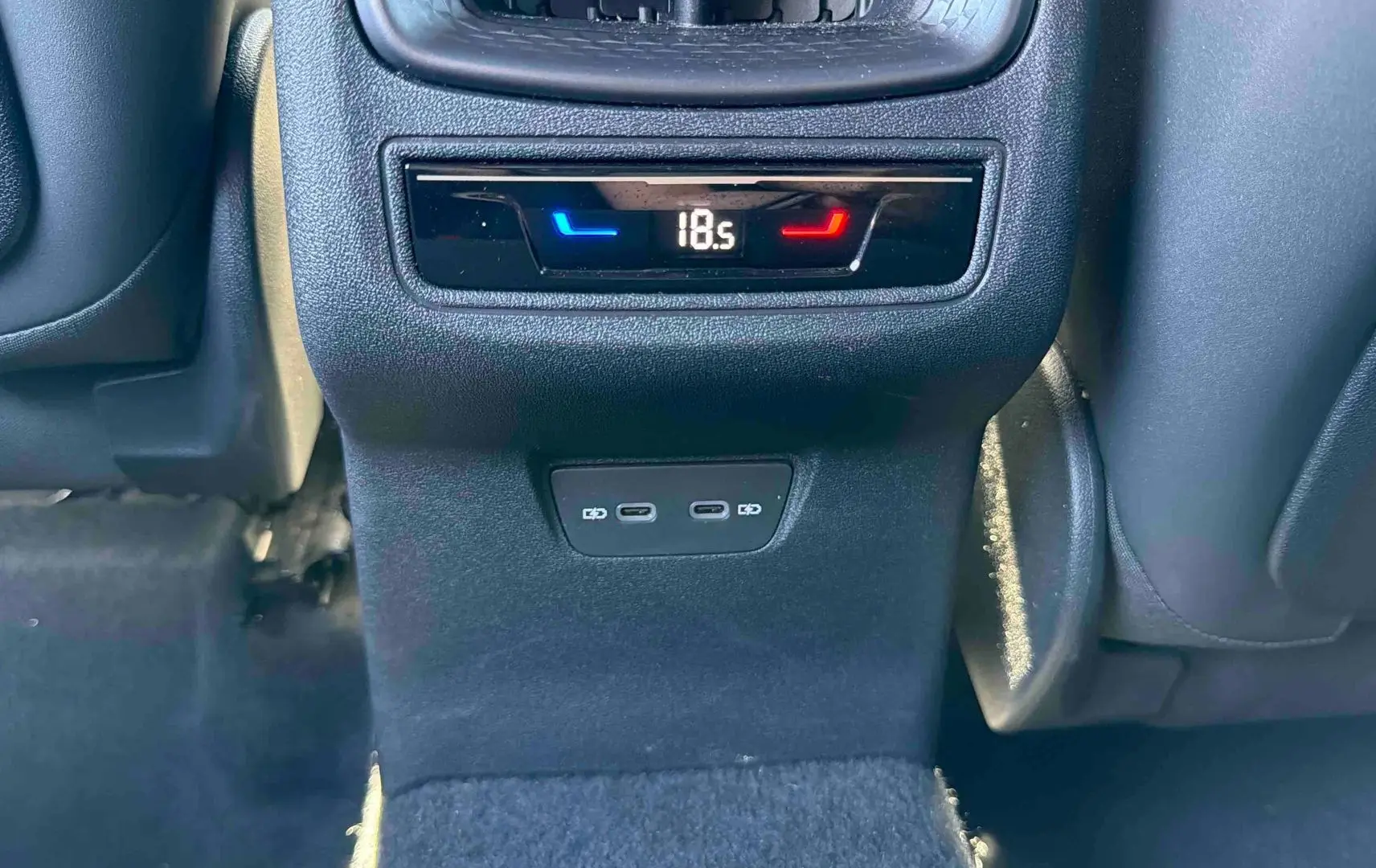 Détail de la console arrière intérieure du CUPRA TERRAMAR gris, avec affichage de la climatisation et ports USB-C.