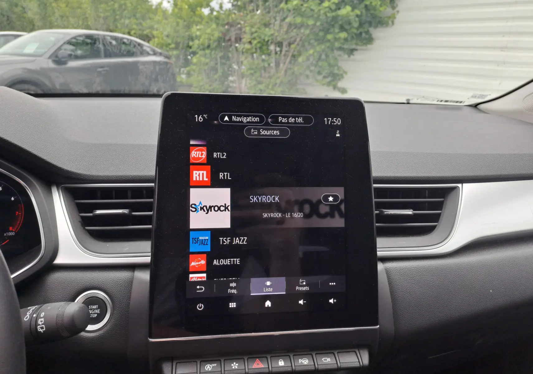 Écran tactile central du tableau de bord du Renault Captur 2024, affichant les stations radio avec commandes en dessous.