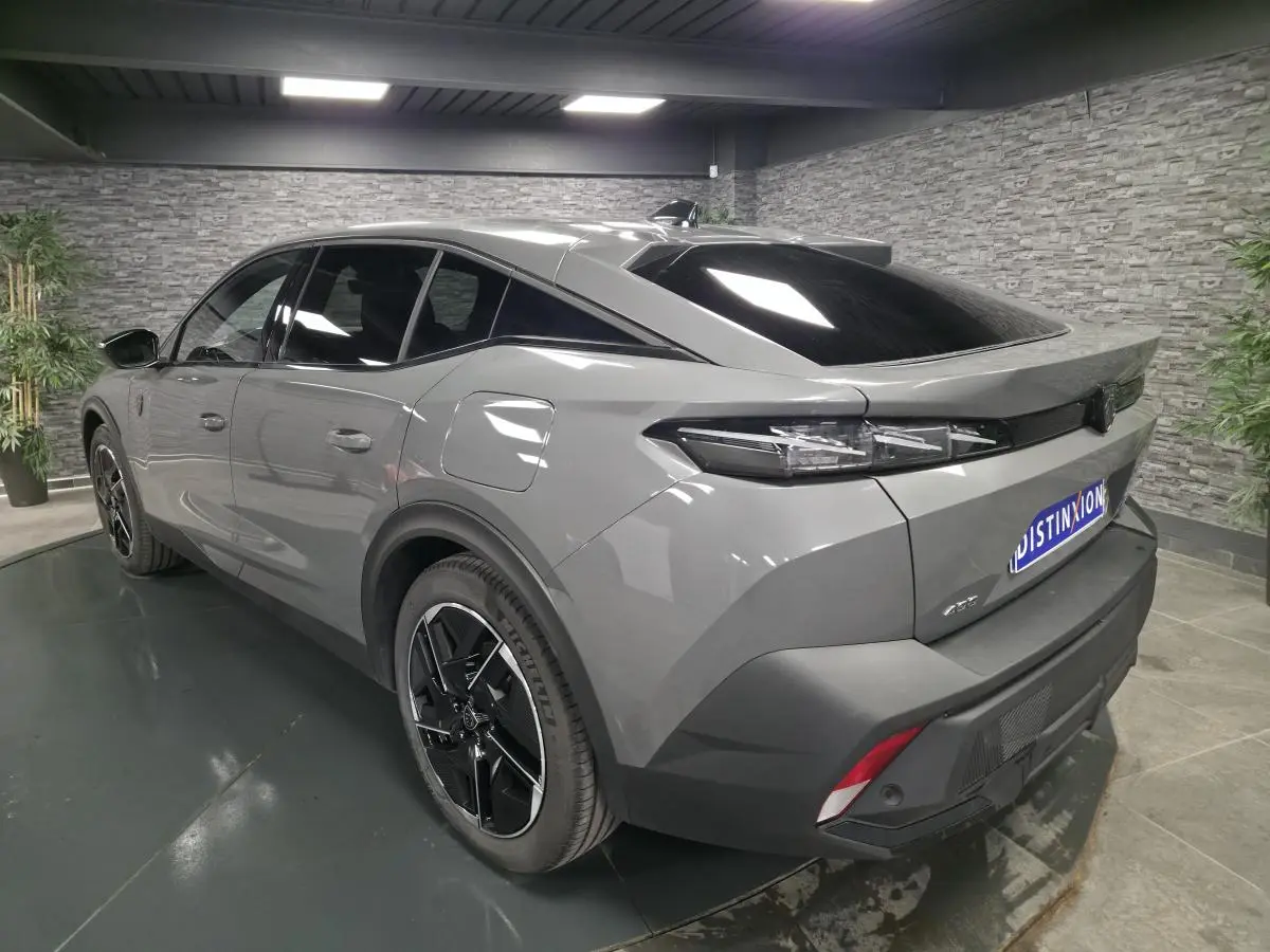 Vue 3/4 arrière droite de la Peugeot 408 gris métallisé avec jantes alliage 19 pouces et feux arrière LED griffés.