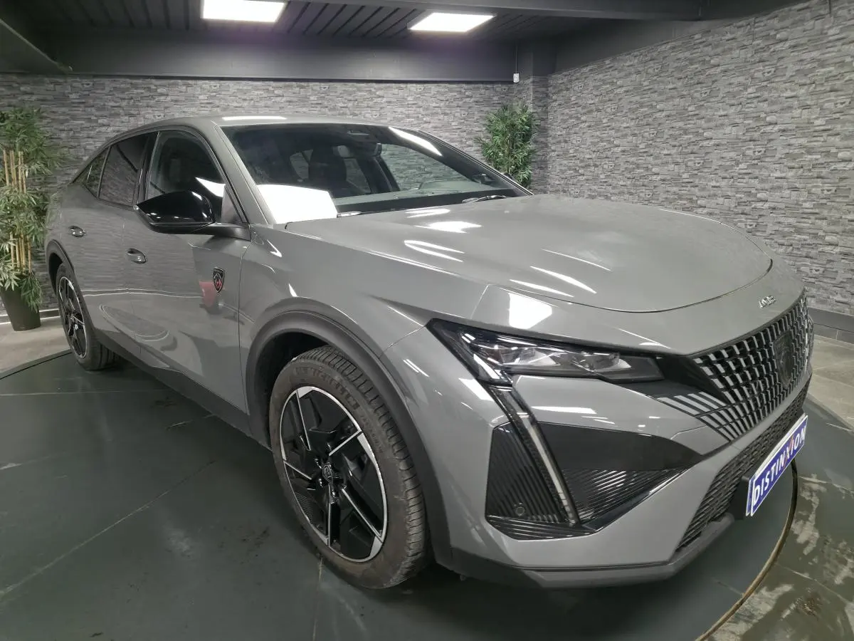 PEUGEOT 408 gris Selenium en 3/4 avant droit, avec calandre verticale et jantes alliage 19 pouces diamantées Graphite.