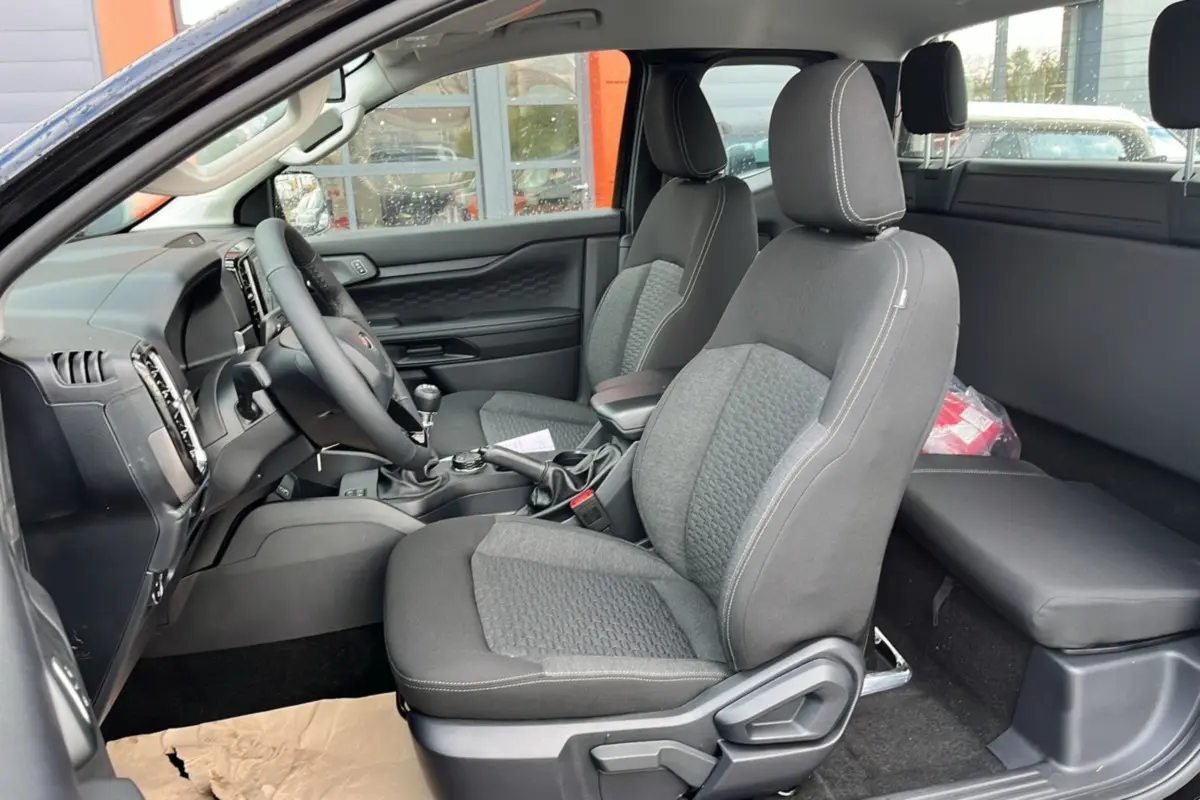 Vue intérieure côté conducteur du Ford Ranger 2025 noir shadow, montrant les sièges avant et la console centrale.