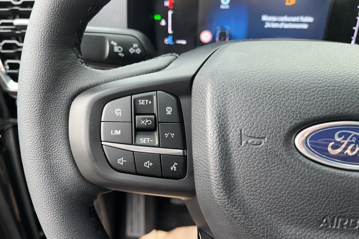 Gros plan sur la partie gauche du volant cuir multifonctions d'un Ford Ranger noir Shadow avec commandes intégrées.