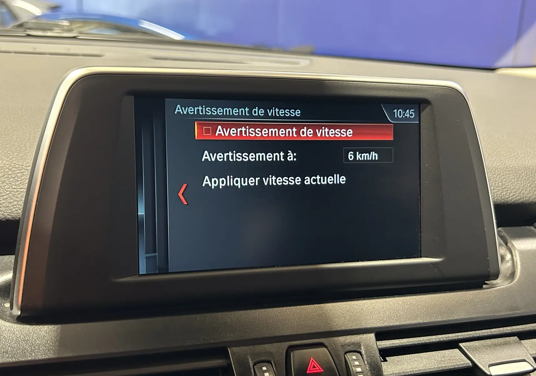 Écran central du tableau de bord d'une BMW Série 2 Active Tourer 216d blanc, affichant l'alerte de vitesse à 6 km/h.