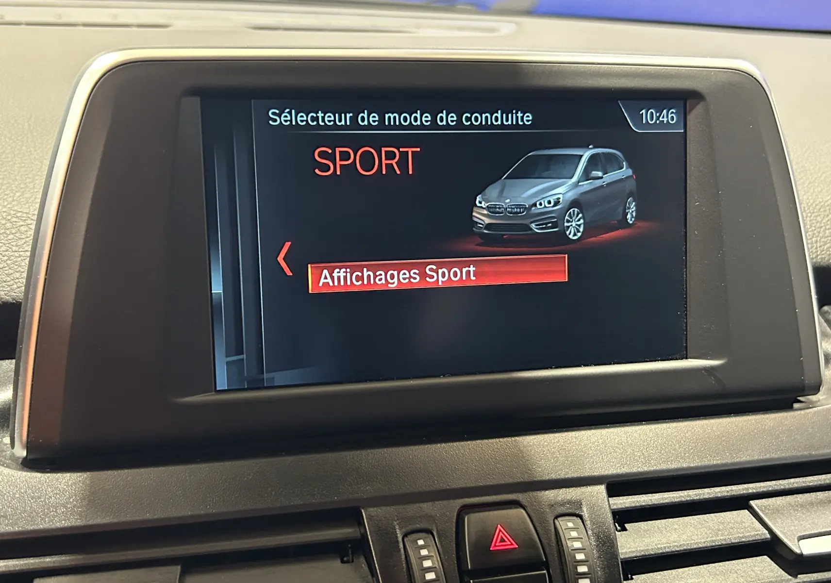 Écran central affichant le mode de conduite Sport avec une image 3/4 avant d'une BMW Série 2 Active Tourer grise.