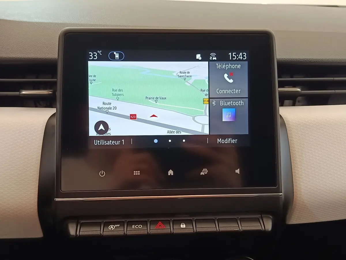 Écran tactile central affichant la navigation et options Bluetooth dans le tableau de bord d'une Renault Clio blanche.