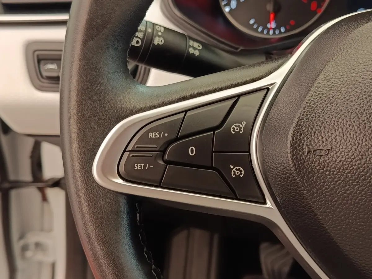 Gros plan sur le volant multifonctions noir de la Renault Clio Evolution TCe 100 GPL avec commandes de régulateur de vitesse.