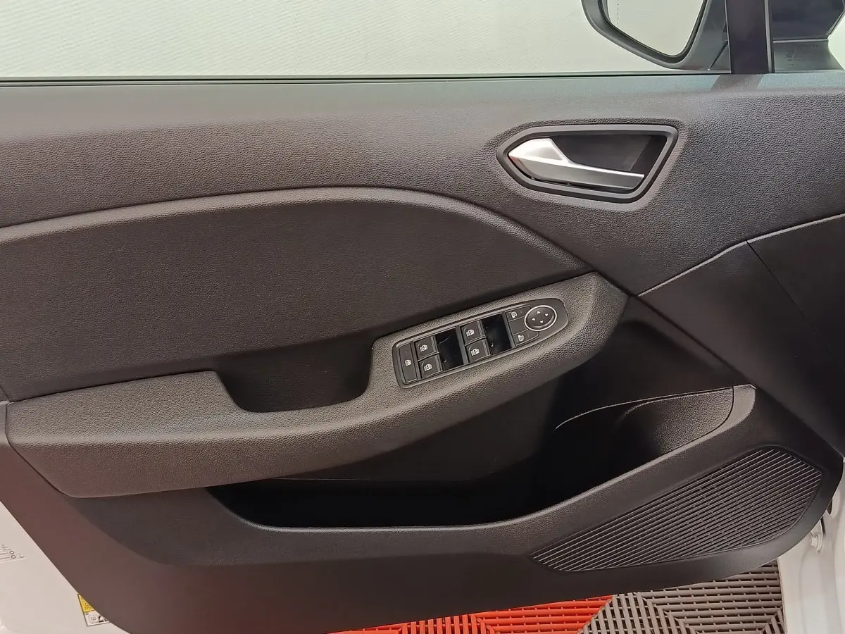 Vue intérieure du panneau de porte avant gauche de la Renault Clio blanche, avec commandes électriques des vitres et rétroviseurs.
