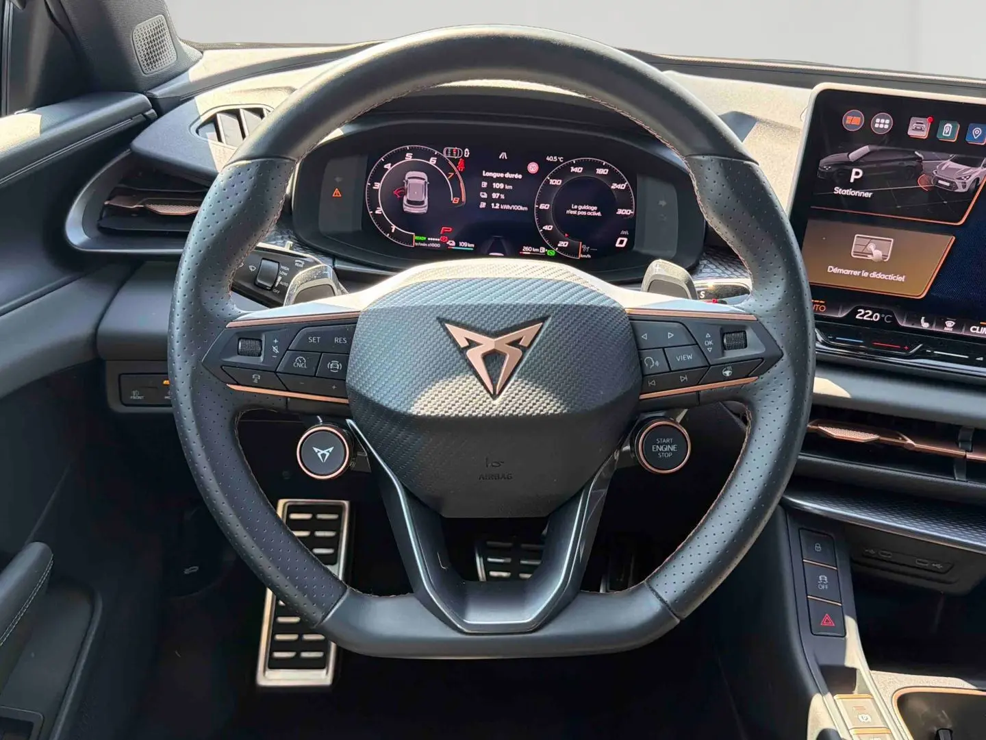 Vue centrée sur le volant sport cuir noir perforé avec logo CUPRA cuivré et tableau de bord numérique du Terramar 2025.