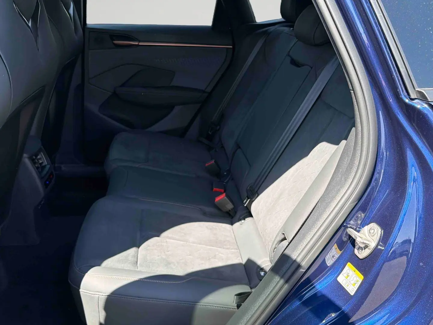 Vue intérieure côté droit des sièges arrière en suédine grise du CUPRA Terramar bleu métallisé avec portière ouverte.