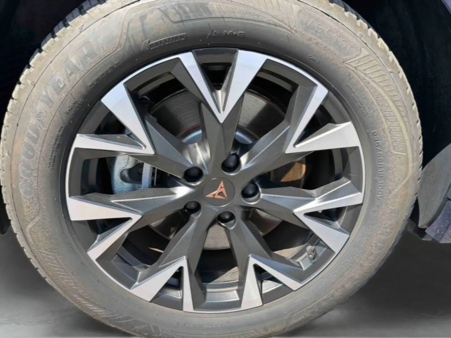 Gros plan sur la jante alliage gris anthracite et argentée avec logo CUPRA cuivré sur roue avant droite du CUPRA Terramar bleu.
