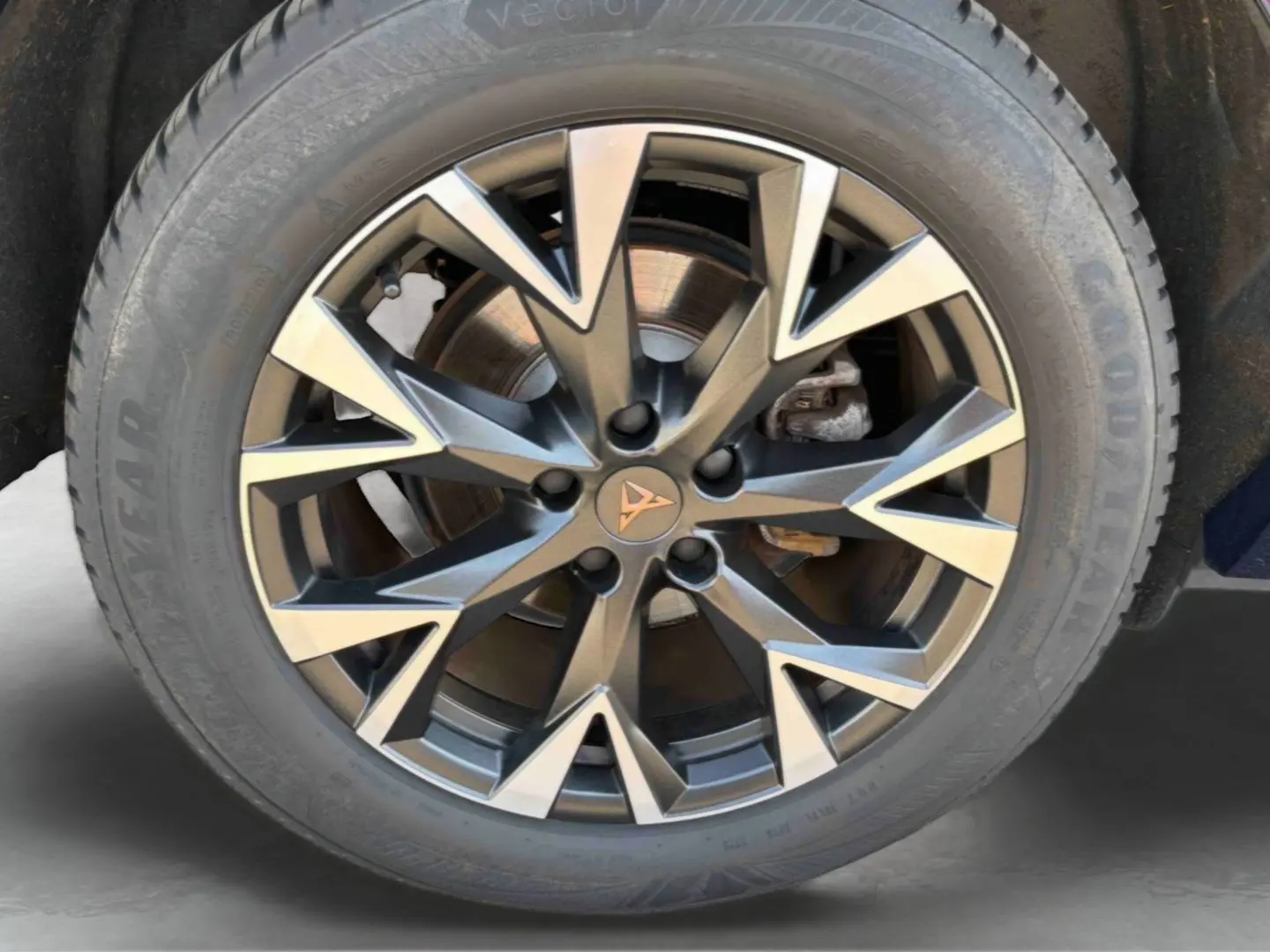 Gros plan sur la jante alliage 18 pouces au design géométrique bicolore avec logo CUPRA central, pneu Goodyear visible.