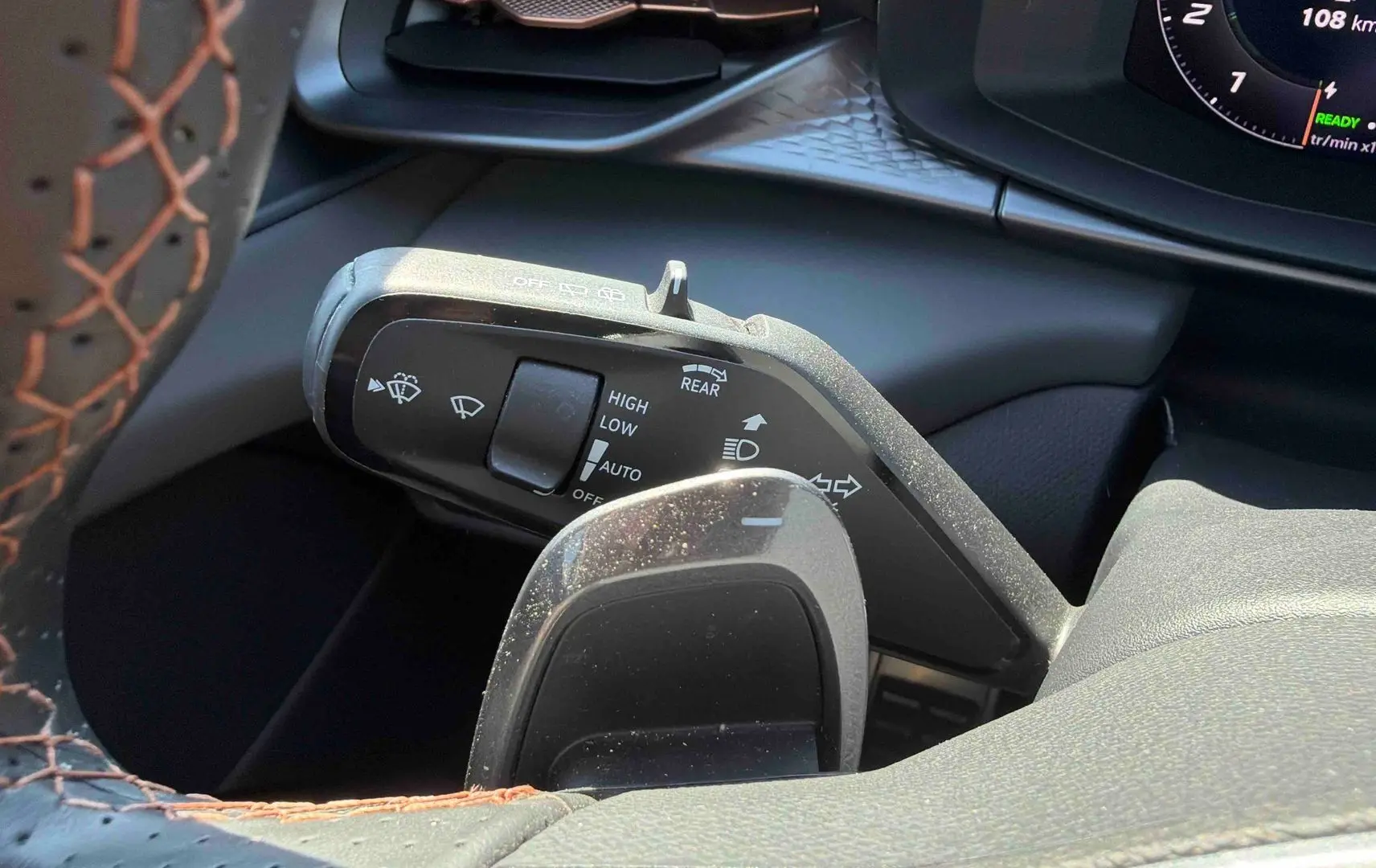 Gros plan sur la manette de commandes au volant cuir noir avec surpiqûres cuivrées du CUPRA Terramar 2025.