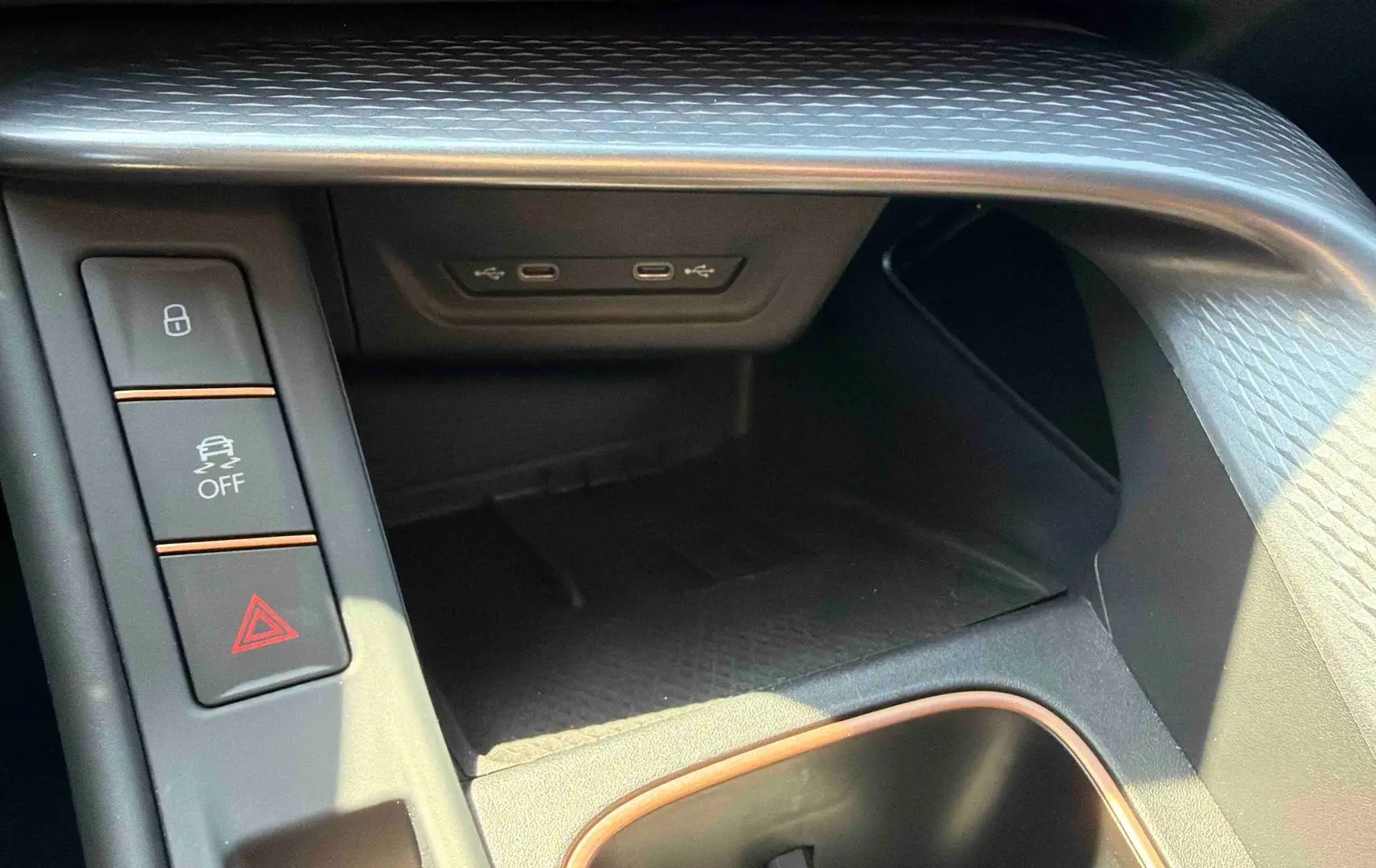 Gros plan sur la console centrale noire texturée du CUPRA Terramar avec boutons de sécurité et ports USB-C.