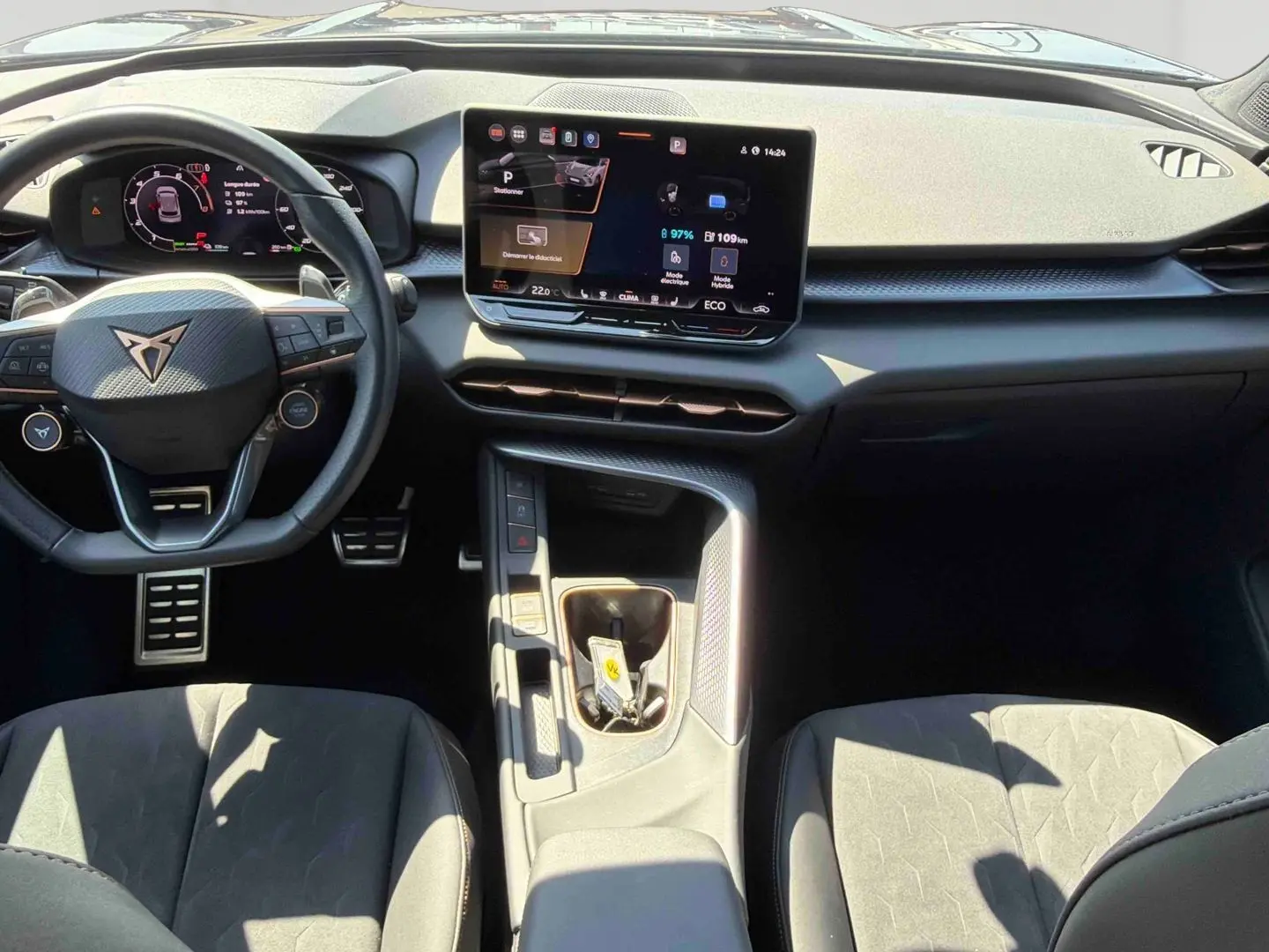 Vue intérieure du tableau de bord et volant noir de la CUPRA Terramar 2025 avec écran tactile central et sièges sport gris.
