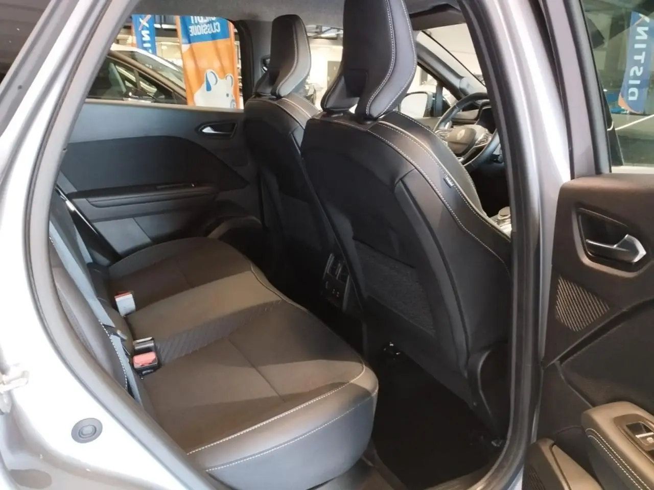 Vue intérieure côté droit sur la banquette arrière noire et les sièges avant du Renault Symbioz gris Cassiopée 2025.