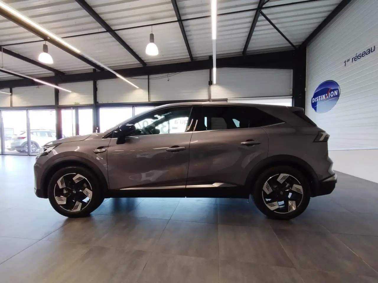 Profil droit du Renault SYMBIOZ 2025 gris Cassiopée avec jantes 18 pouces Gravity et détails noirs brillants.