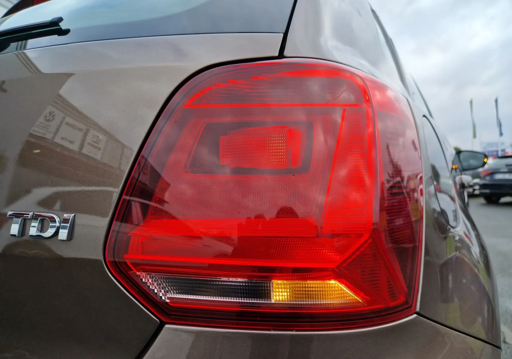 Gros plan sur le feu arrière droit d'une Volkswagen Polo 1.4 TDI brun 2015 avec logo TDI visible sur la carrosserie.
