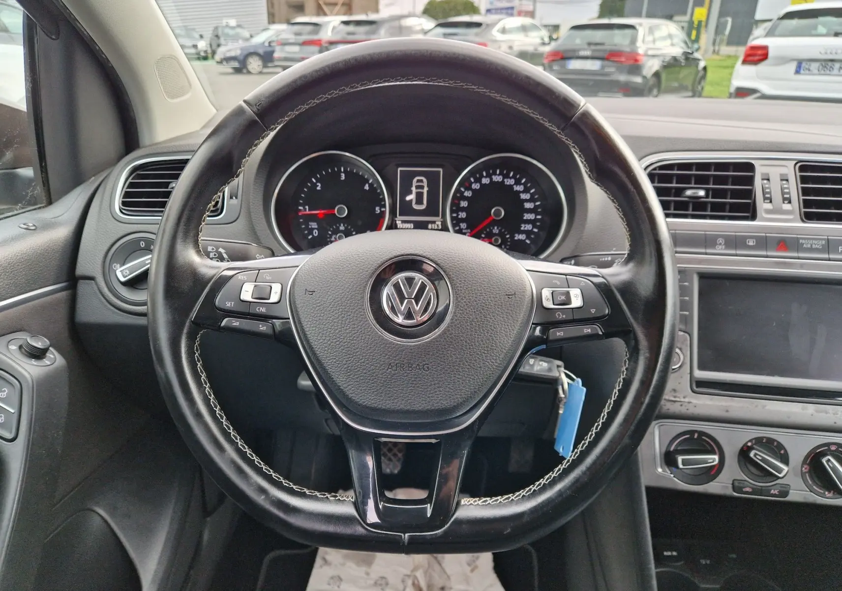 Vue intérieure centrée sur le volant cuir noir de la Volkswagen Polo 1.4 TDI 2015 avec tableau de bord et commandes visibles.