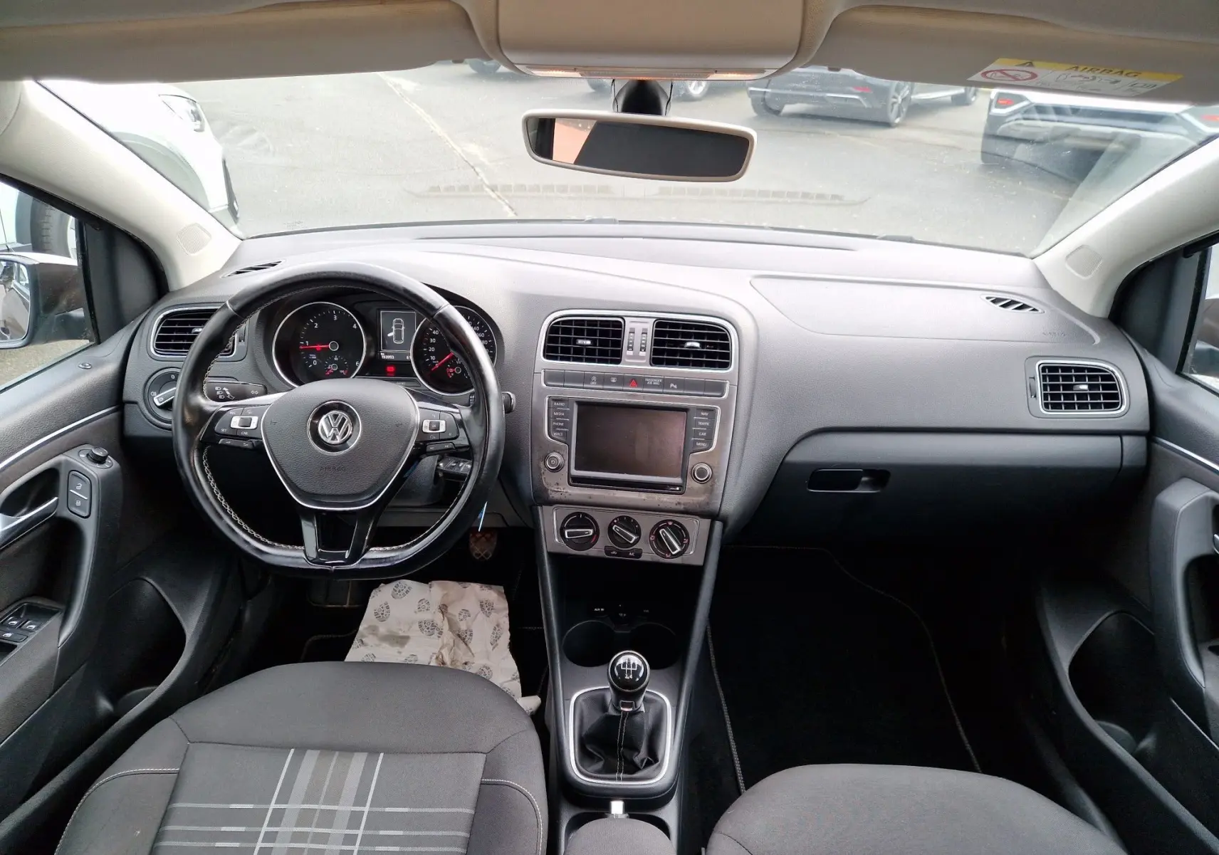 Vue intérieure avant du tableau de bord d'une Volkswagen Polo 1.4 TDI 2015 finition Lounge, avec volant cuir multifonction et levier de vitesse manuel.