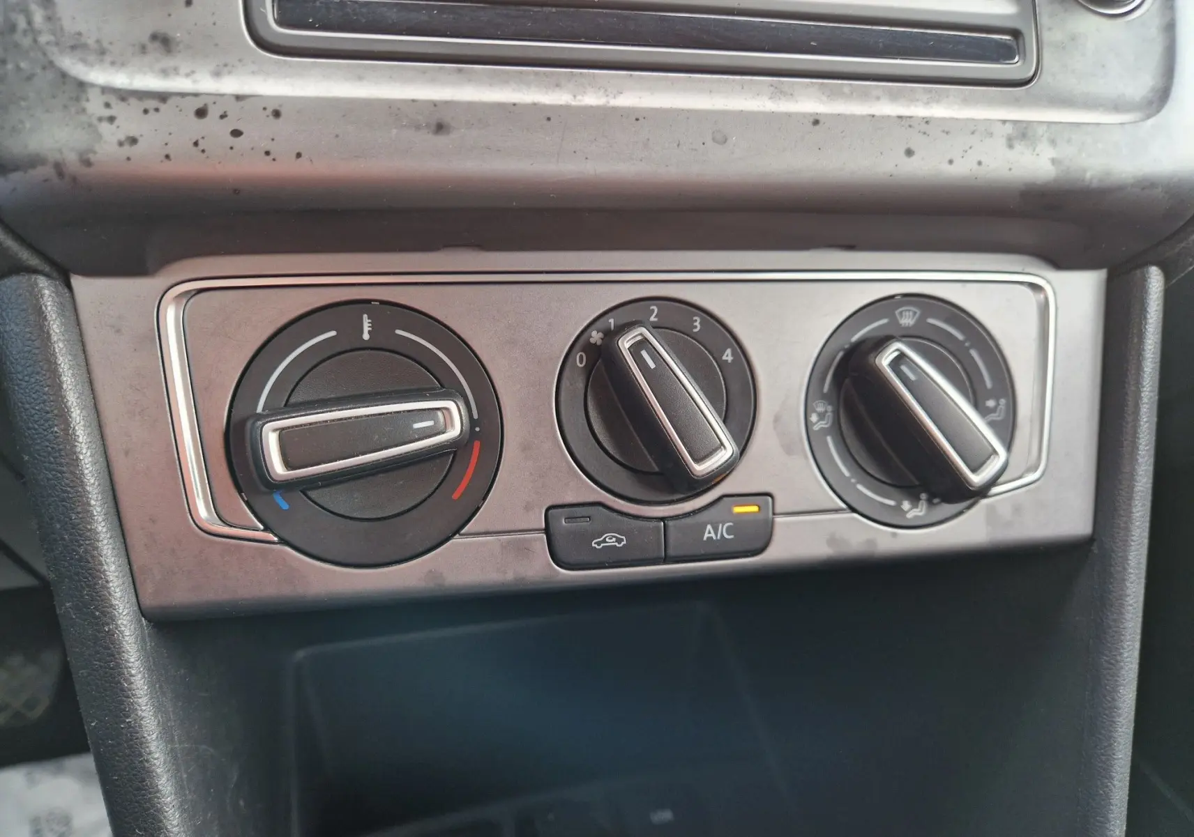 Gros plan sur les commandes de climatisation de la Volkswagen Polo 1.4 TDI 2015, finition Lounge, avec réglages manuels.