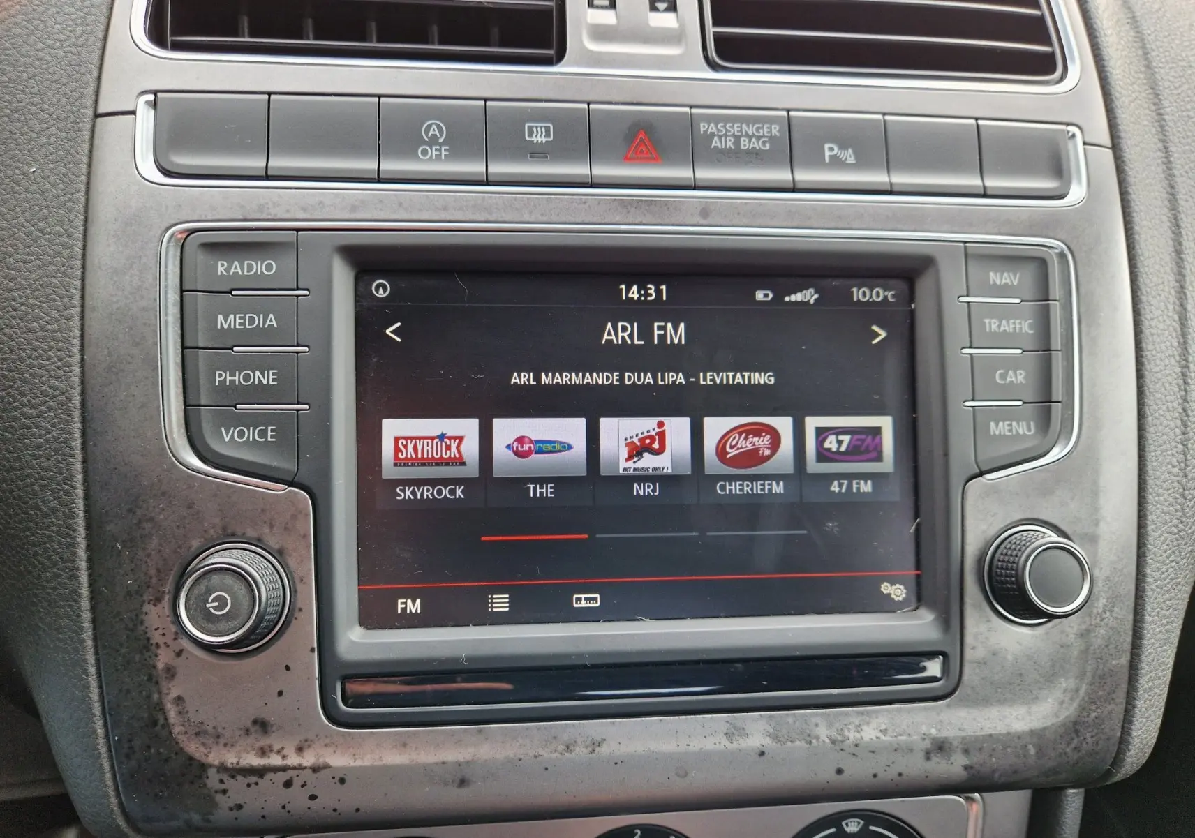Vue rapprochée de l’écran multimédia central de la Volkswagen Polo 1.4 TDI 2015 avec interface radio et boutons de commande.