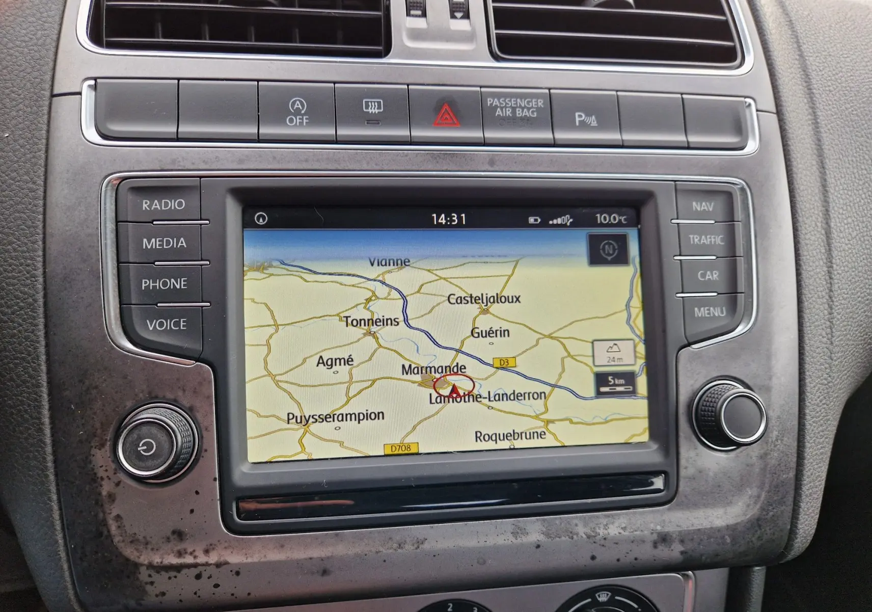 Vue rapprochée de l’écran GPS central de la Volkswagen Polo 2015 finition Lounge avec cadre brun et commandes autour.