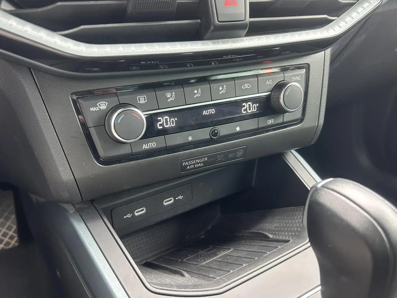 Gros plan sur la console centrale du SEAT Arona 2025, montrant la climatisation automatique bi-zone et les ports USB.