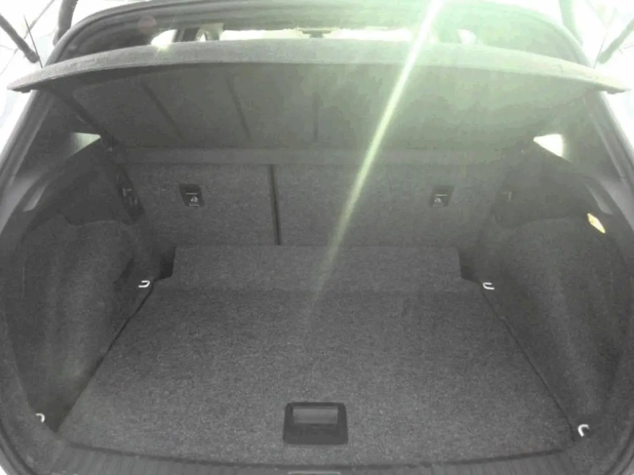 Vue intérieure du coffre spacieux et vide du SEAT ARONA blanc Nevada, avec hayon ouvert vers le haut.