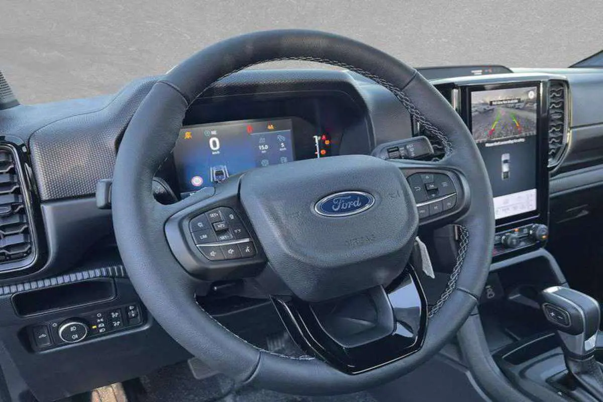 Vue intérieure du volant cuir multifonctions et tableau de bord numérique du Ford Ranger 2025, avec écran tactile central.