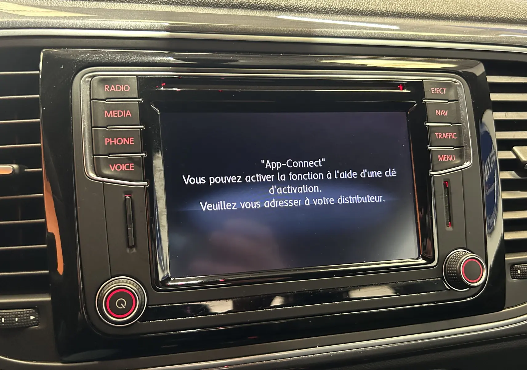 Gros plan sur l'écran tactile central du GPS de la Volkswagen Coccinelle 2016, avec interface App-Connect affichée.