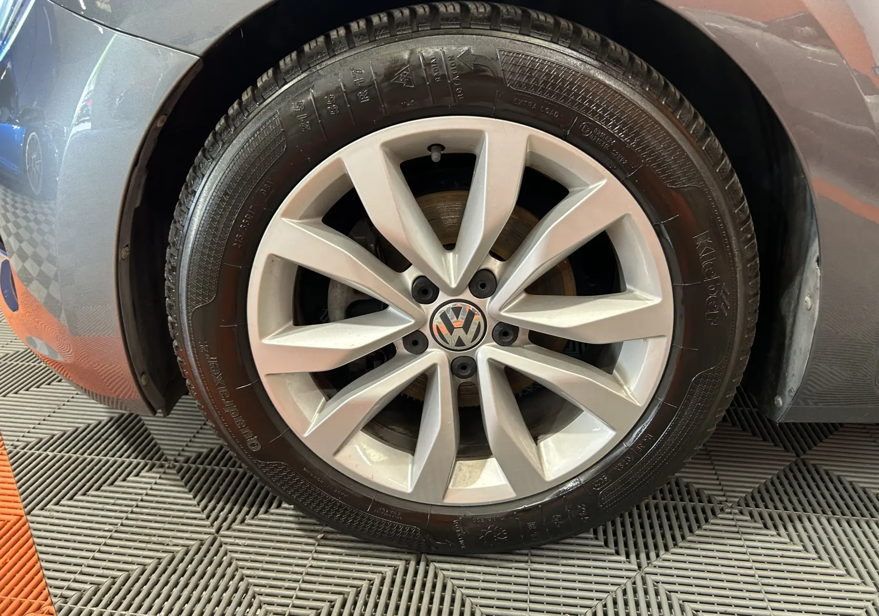 Gros plan sur la roue avant droite grise d'une Volkswagen Coccinelle 2016 avec jante alliage à 10 branches.
