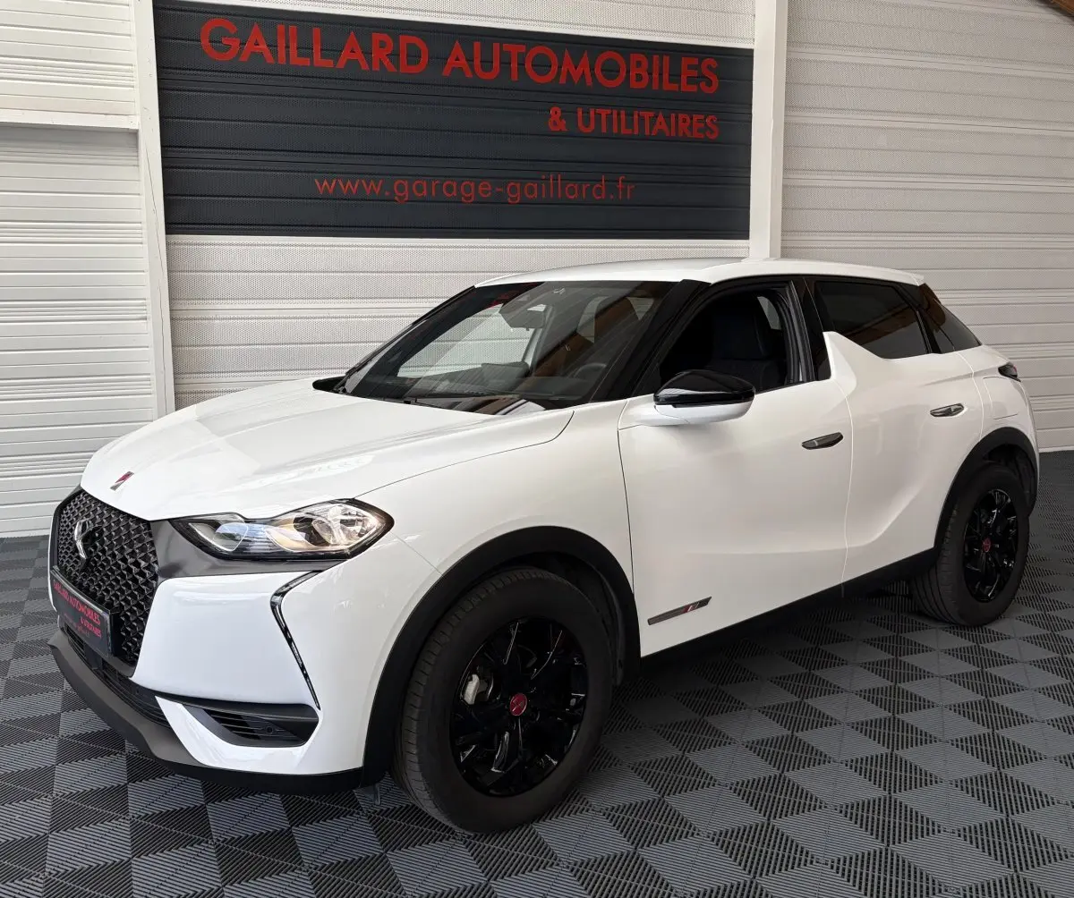 Vue 3/4 avant droite d'un DS3 Crossback blanc avec jantes noires et rétroviseurs électriques noirs.