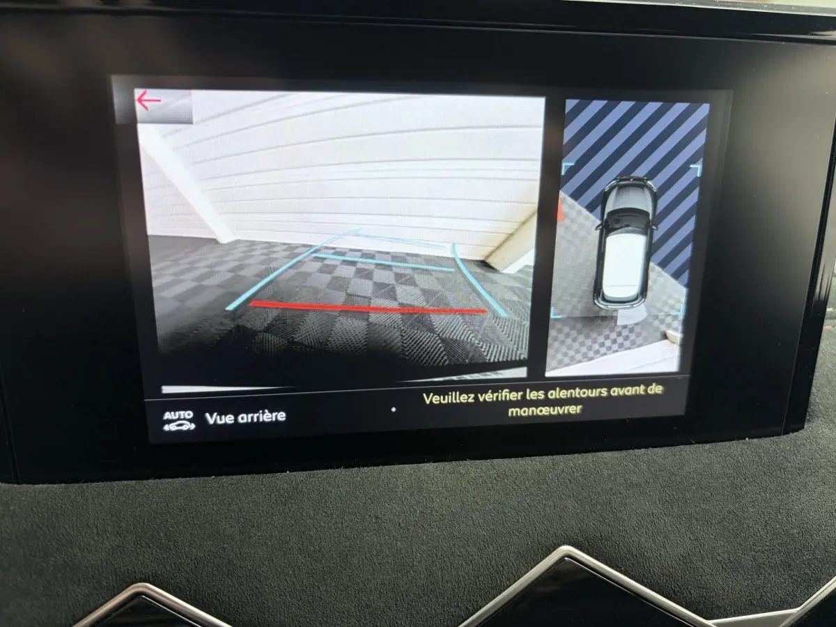 Écran tactile du DS3 Crossback blanc montrant la caméra de recul et la vue aérienne du véhicule en stationnement.