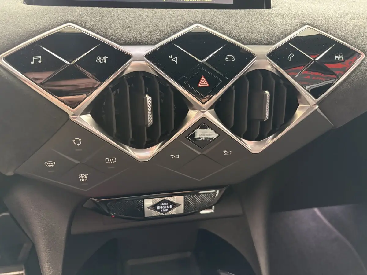 Vue rapprochée du tableau de bord central du DS3 Crossback blanc, avec commandes tactiles et bouton start/stop.