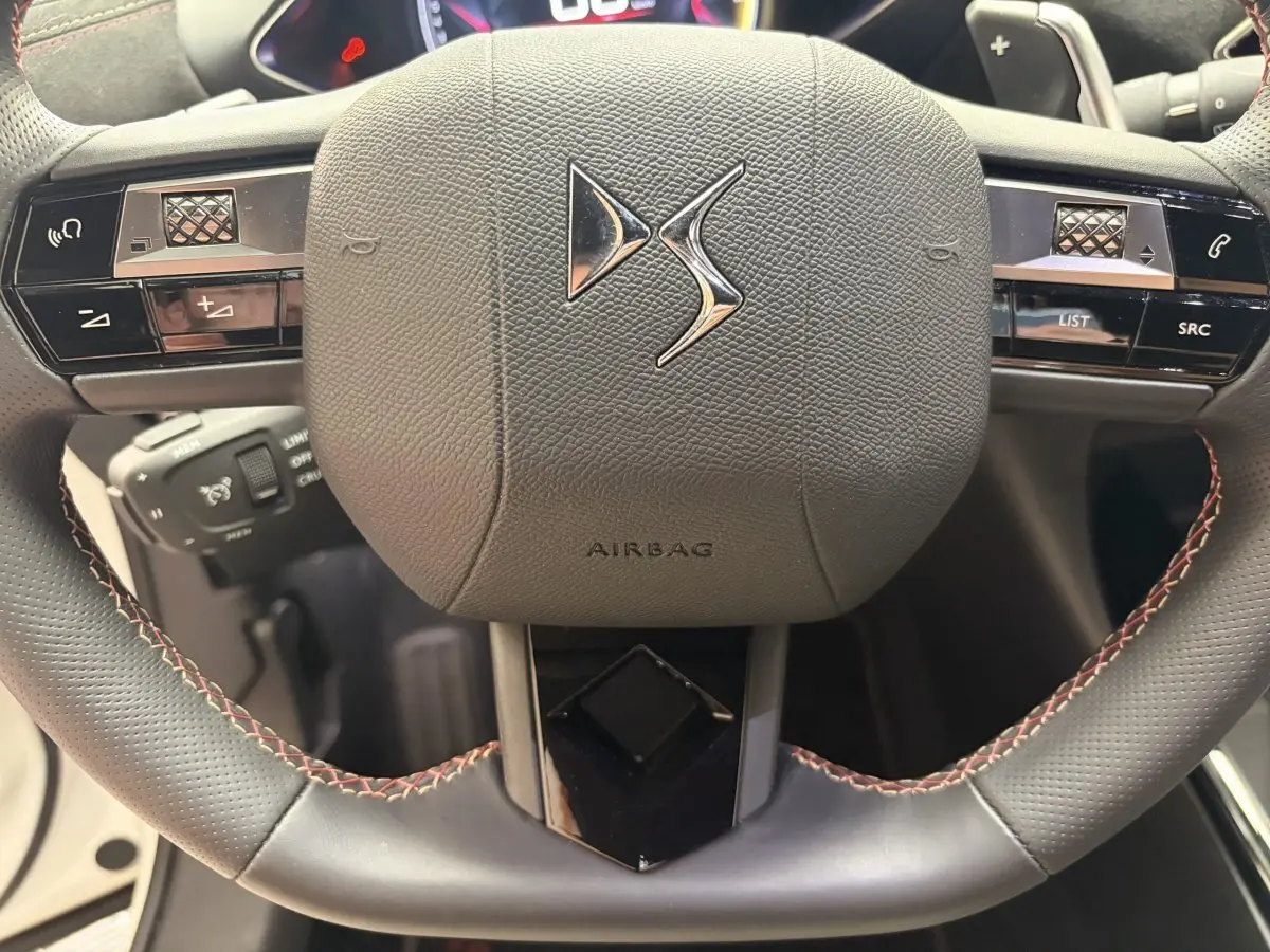 Gros plan sur le volant cuir noir du DS3 Crossback 2022 avec commandes multifonctions et logo DS central.
