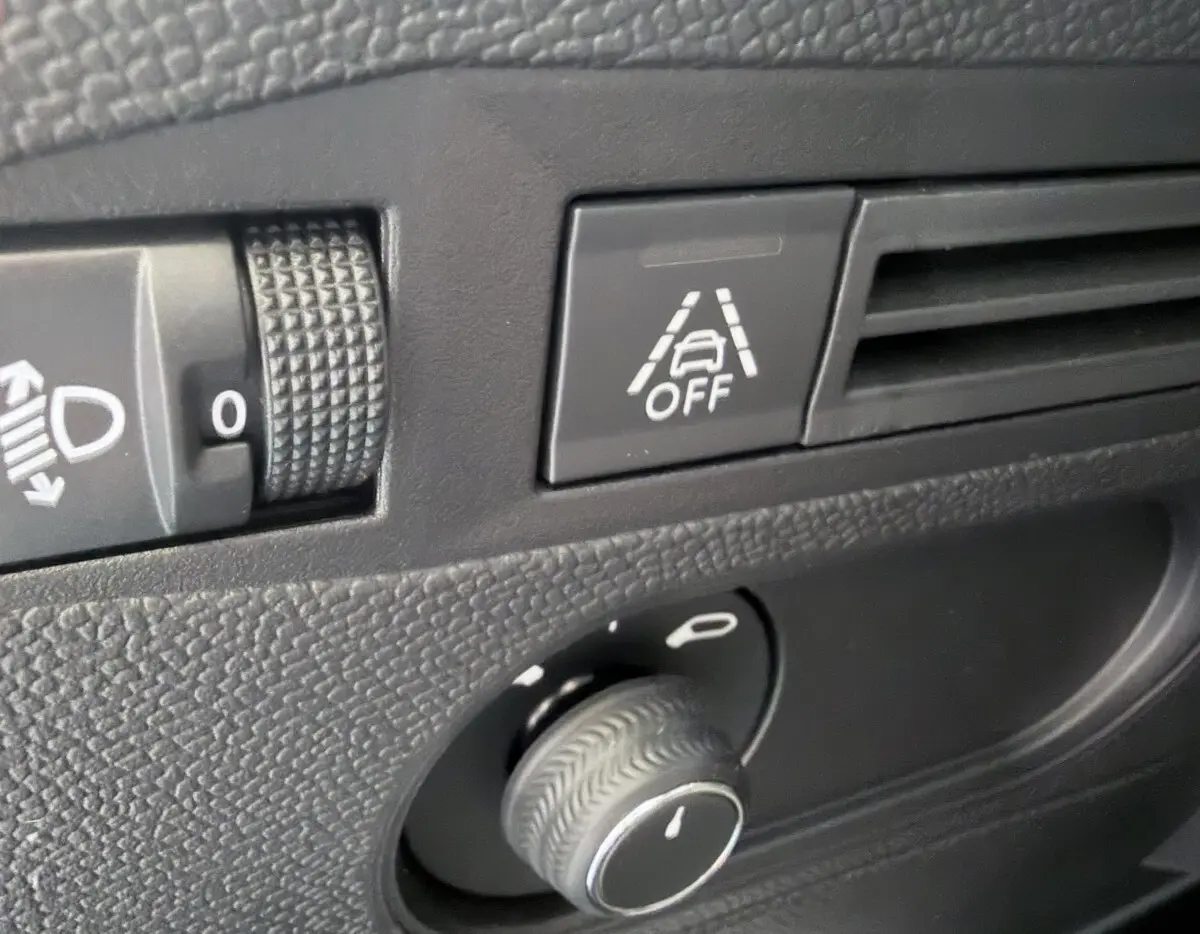 Gros plan sur le tableau de bord du DS3 Crossback 2022, bouton d'alerte franchissement de ligne et réglage des phares.