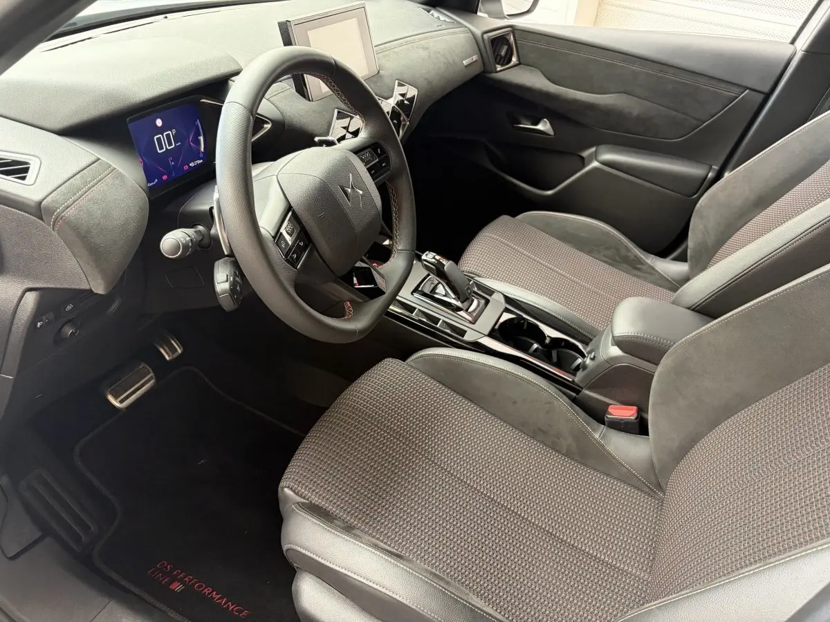 Intérieur vue côté conducteur du DS3 Crossback 2022, sièges tissu gris, volant cuir multifonctions et écran tactile central.
